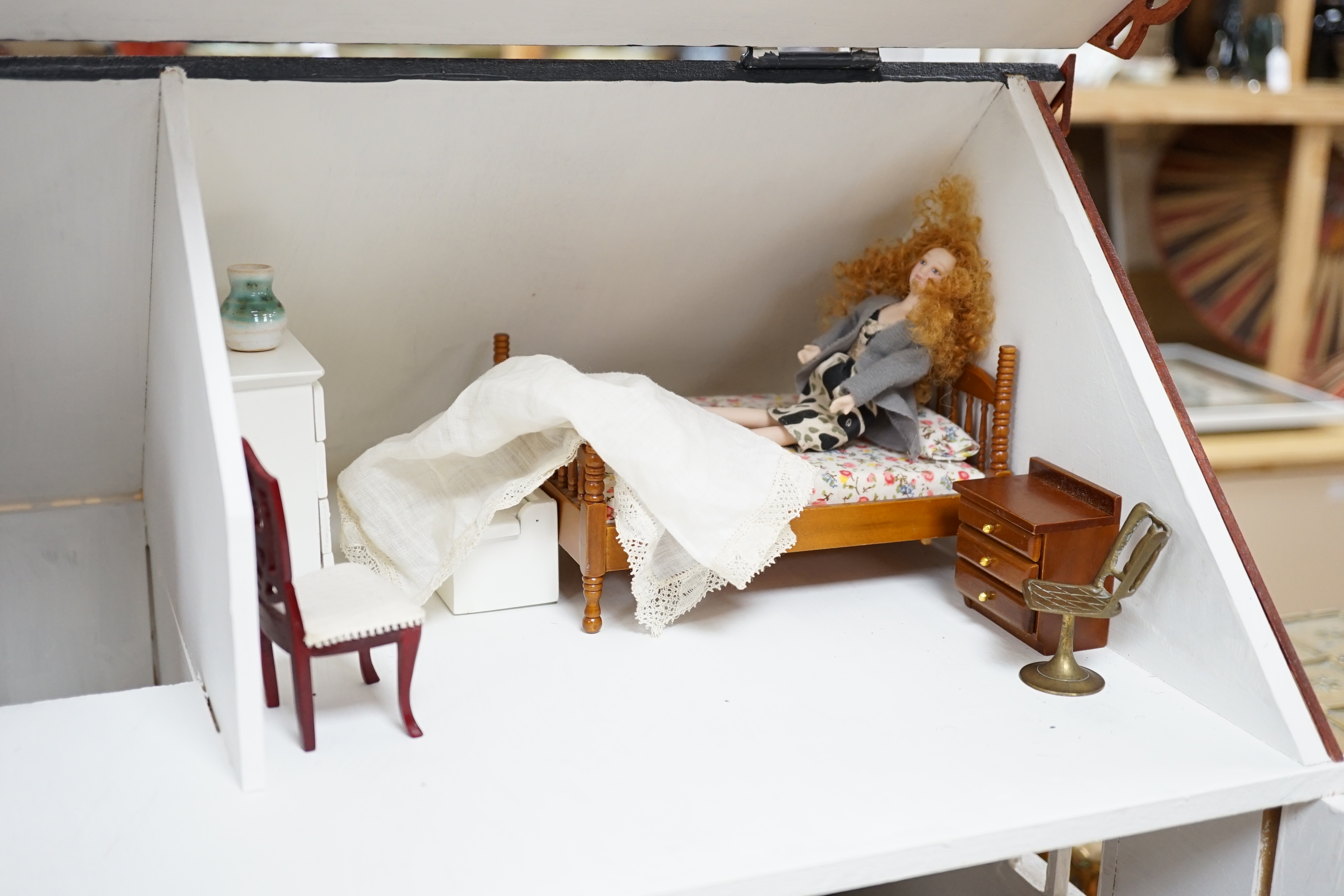 A painted doll's house with dolls and furniture, dolls house 78.5cm wide, 67cm high